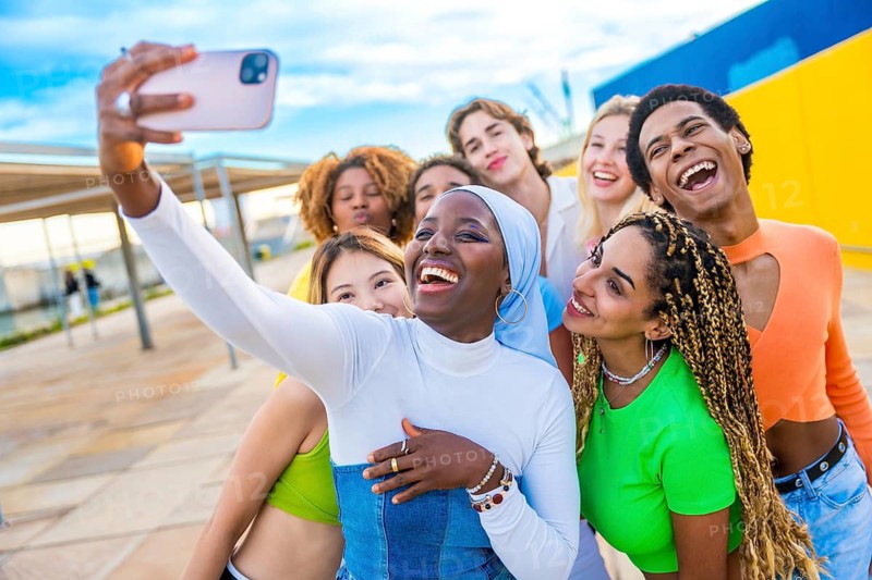 Happy muslim african woman taking a selfie while laughing with friends