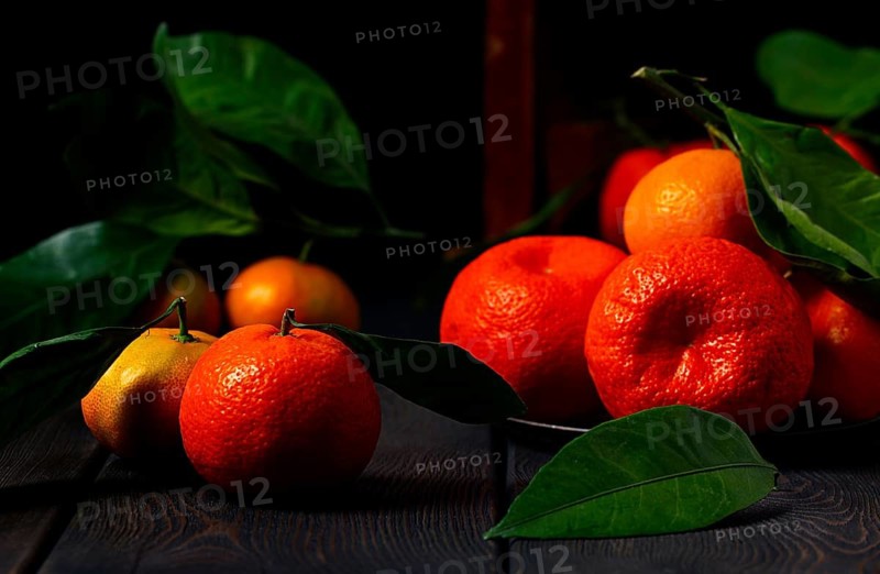 Fresh tangerines with leaves, close-up, on a wooden table, horizontal, no people