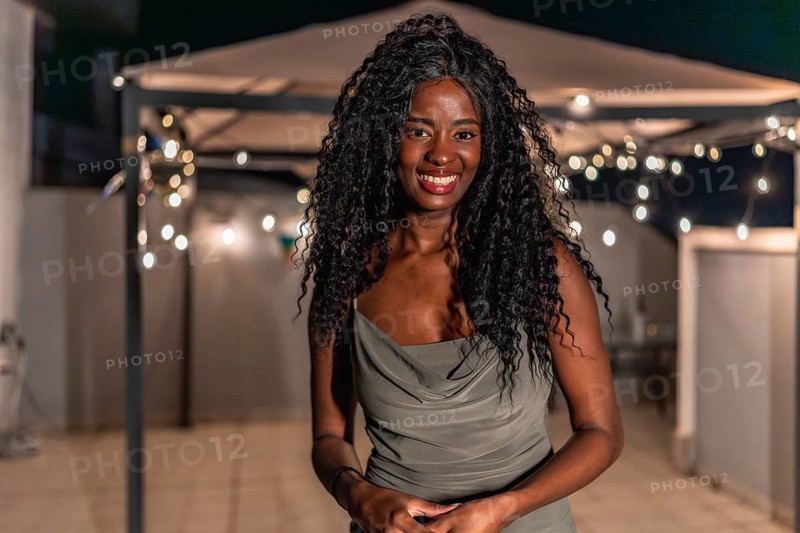 Portrait of a beauty african woman standing smiling at camera in a night roof party