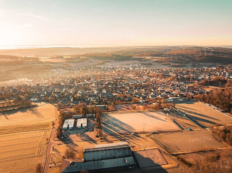 Sweeping view of a small town surrounded by fields and forests at sunrise, Gechingen, Heckengäu region, Calw district, Germany