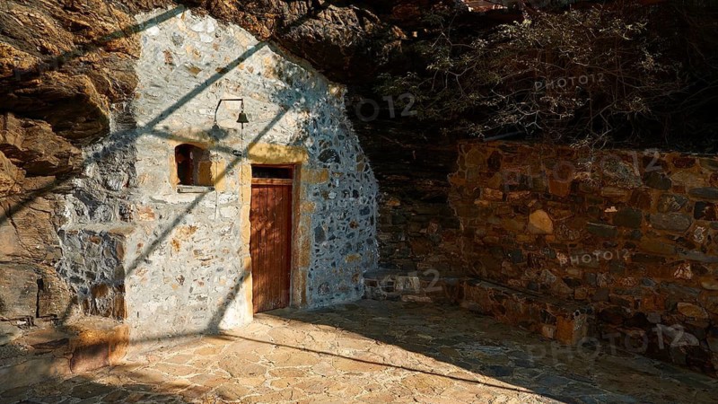 Agios Onoufrios rock church, paved forecourt, small bell, shade, Ravdoucha, Rodopou peninsula, western Crete, island of Crete, Greece