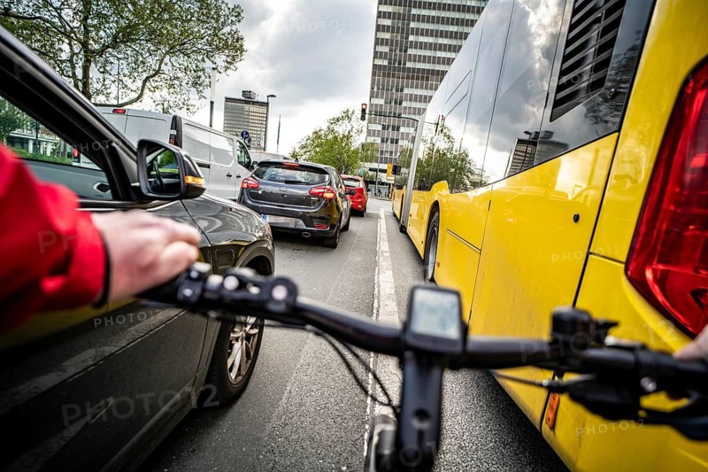 Cycling in the city, city centre road, no cycle path, bus stop, two-lane traffic in both directions, cyclists' perspective, Essen, North Rhine-Westphalia, Germany