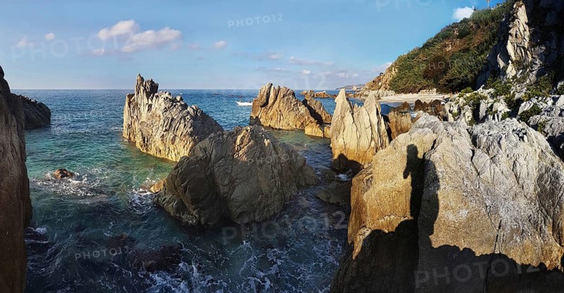Craggy rocks jutting out of the sea on the beach of Lido La Scogliera, Tropea, Vibo Valentia, Calabria, Southern Italy, Italy