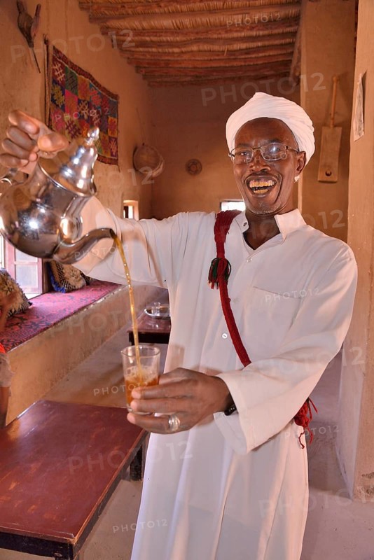 Man pouring tea into a glass, Merzouga, Meknès-Tafilalet region, Morocco