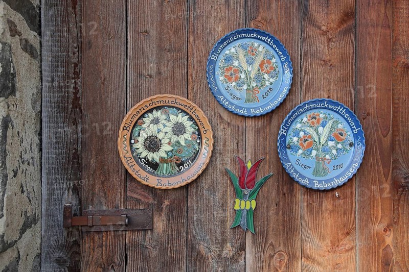 Three painted and decorative plates as award, prize, profit for at wooden door in the old town, arts and crafts, Babenhausen, Hesse, Germany