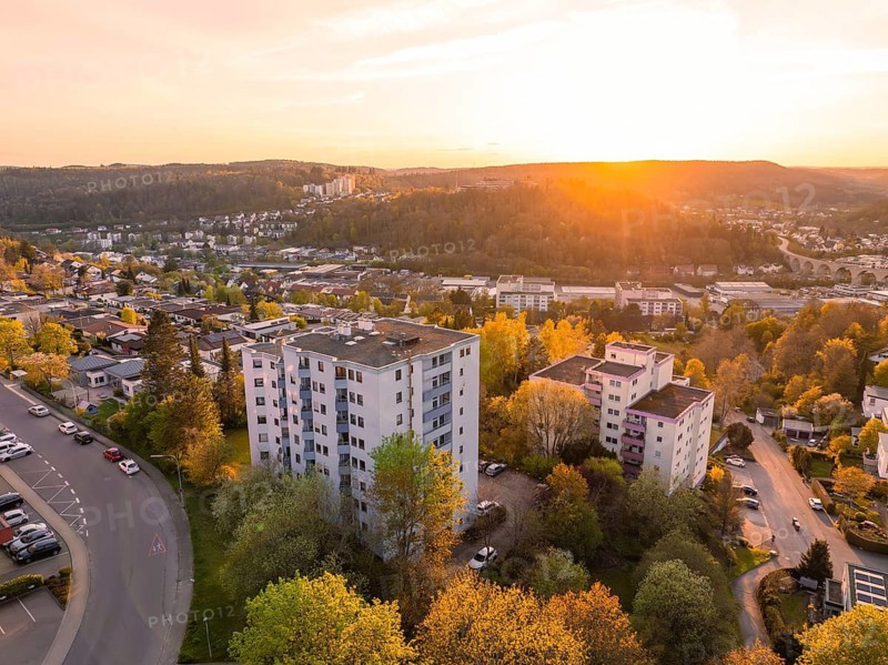 Urban housing estate with high-rise buildings and green trees in the warm light of the sunset, Nagold, Calw district, Germany
