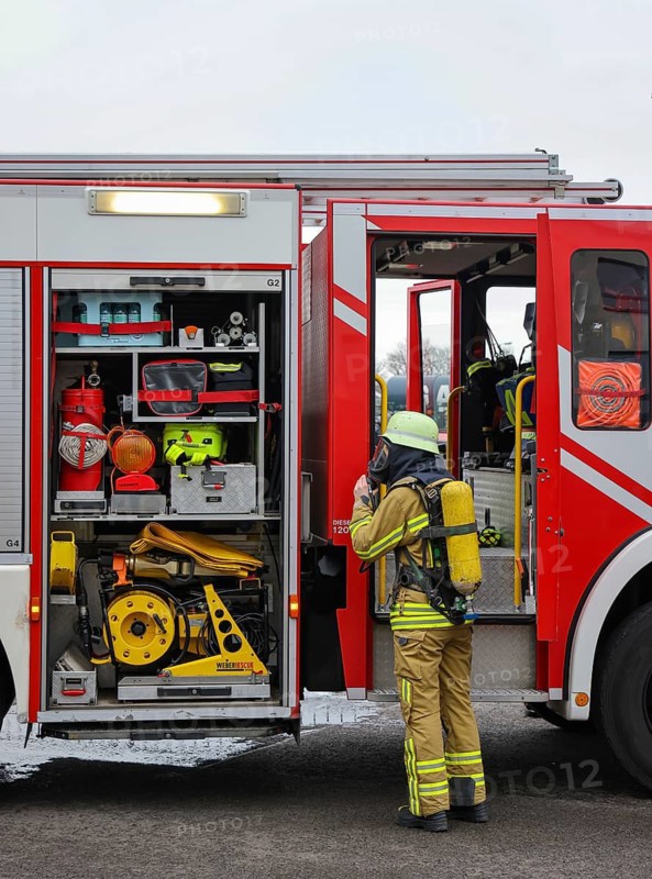Duisburg, North Rhine-Westphalia, Germany, firefighting exercise, people are rescued from a burning flat. Firefighter returns to the fire engine after the operation. Press event: Federal Chancellor Olaf Scholz visits Fire Engine 530 of the Duisburg Volunteer Fire Brigade at Fire and Rescue Station 5 in Homberg. Together with a training unit of the professional fire brigade, the fire brigade school is also housed there