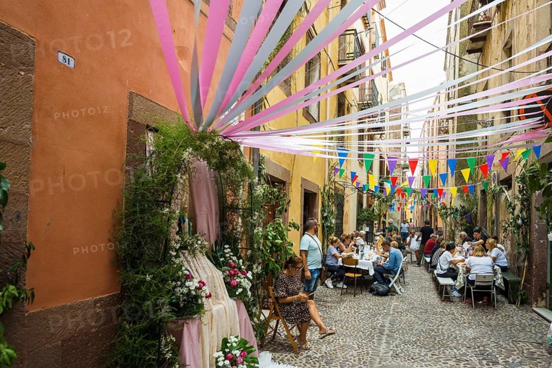 Decorated alley and celebrating people, feast of the Madonna of Regnos Altos, Bosa, district of Oristano, Sardinia, Italy