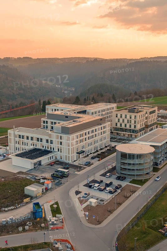 Large modern building in rural area at sunset, surrounded by fields, new hospital of the Verbund Südwest Clinic, Calw, Germany