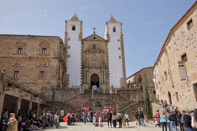 Groups of people at Plaza de San Jorge with church Iglesia de San Francisco Javier with twin towers, UNESCO old town, Caceres, Extremadura, Spain