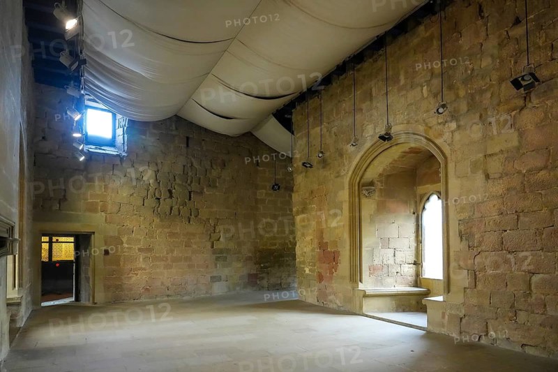 Interior view of the medieval royal palace of olite, navarre, spain, showing restored stone walls and fabric ceiling