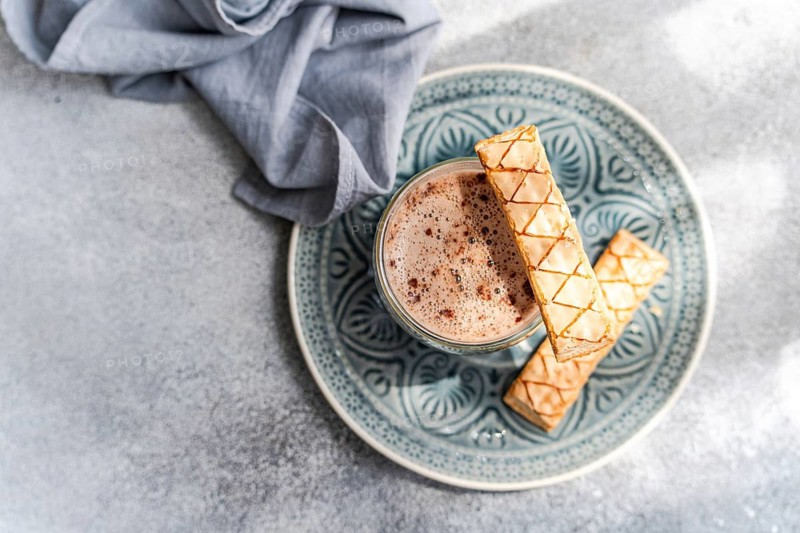 A delightful scene featuring a golden puff pastry filled with sweet apricot jam, perfectly paired with a freshly brewed cup of rich, creamy cocoa, ideal for a cozy treat
