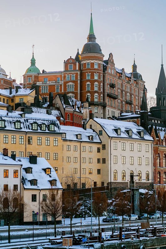 Experience the charm of Stockholm with this image of snow-adorned historical architecture. The picturesque buildings reflect the city's rich cultural heritage and wintry beauty