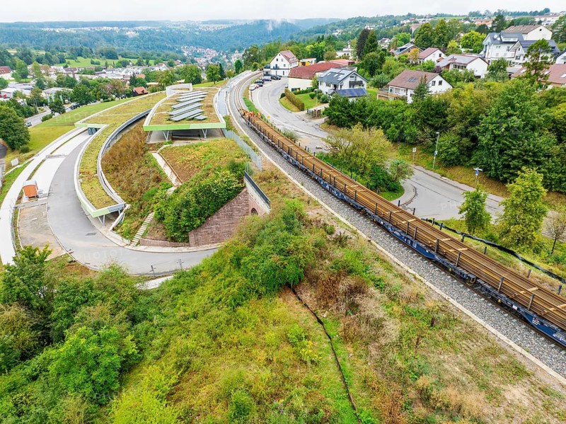 Railway tracks run through a green residential area from an aerial view, track construction, rail delivery for Hermann Hessebahn, Calw, Black Forest, Germany