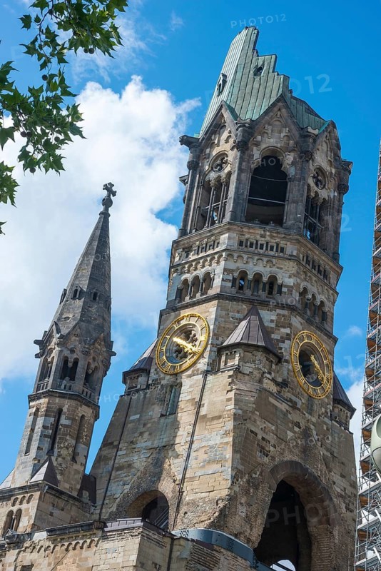 Protestant Kaiser Wilhelm Memorial Church, memorial church, monument with destroyed tower roof, tower ruins, neo-Romanesque, Breitscheidplatz, Charlottenburg district, striking architecture, landmark, memorial against the war, World War II, historical, golden clocks, sight, tourist, attraction, blue sky with white clouds, summer, sunny day, city of Berlin, Germany