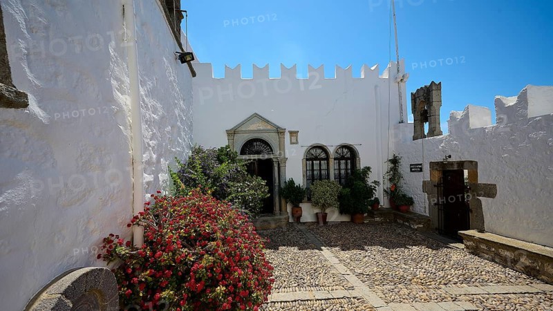 Courtyard with white walls, flower pots and flowering plants, Zoodochou Pigis Monastery, The Springs of Life, Chora, Patmos, Dodecanese, Greek Islands, Greece