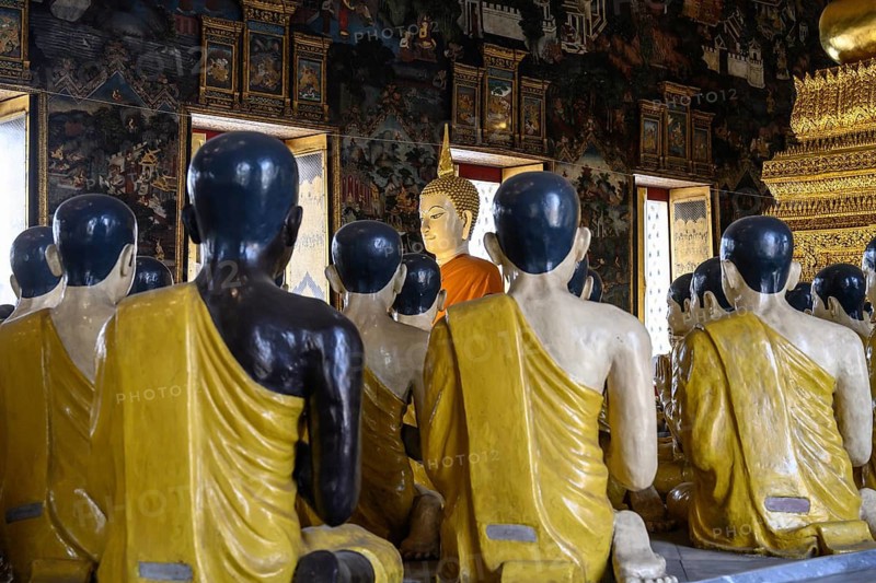 Bangkok, Thailand. February 20th 2025. Around 80 colourful plaster statues of Buddha disciples sit beneath the bronze cast Buddha Statue in the Ordination hall, Wat Suthat Thepwararam