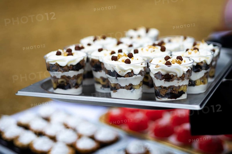 A tray filled with layered parfaits, beautifully arranged and ready for serving at a street fair