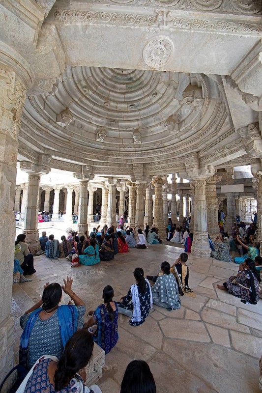 Indian woman praying between the white marble pillars in the Adinath temple in Ranakpur, Jain temple, Rajasthan, India