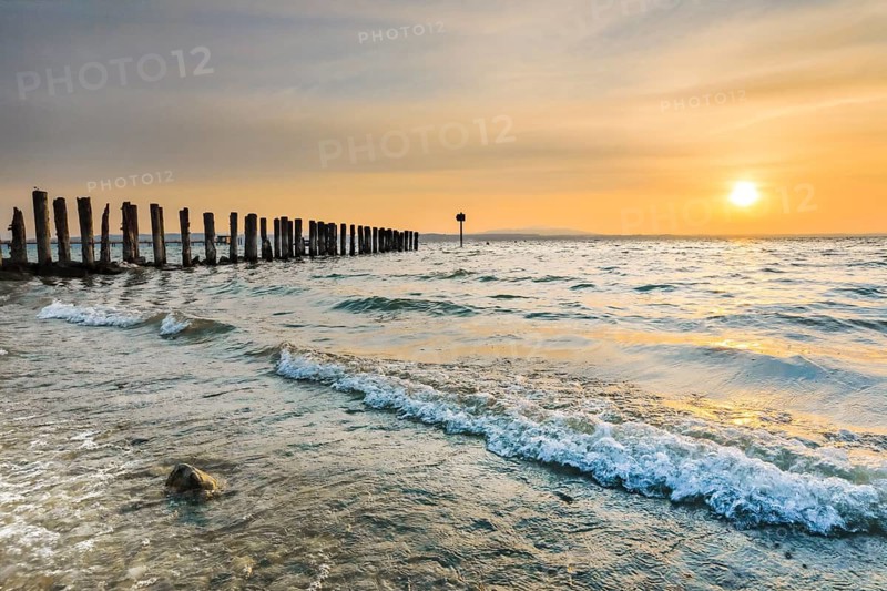 Golden sunrise on the shore of Lake Constance with jetty near Altnau in the canton of Thurgau, Switzerland