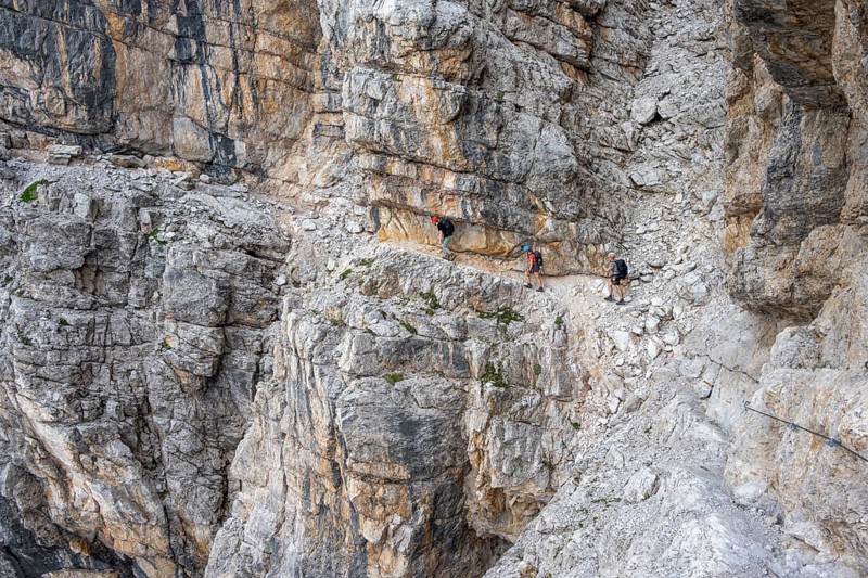 Three hikers on the Via Ferrate Benini via ferrata on a cliff, Brenta Mountains, Parco Naturale Brenta-Adamello, Trentino, Italy
