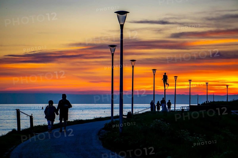 Sunset on the beach of Zoutelande, people on the dike, Zeeland, Netherlands