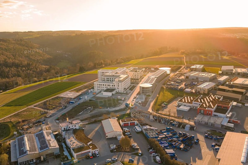 Industrial area with modern buildings and fields bathed in warm light, new hospital at Klinik Verbund Südwest, Calw, Germany