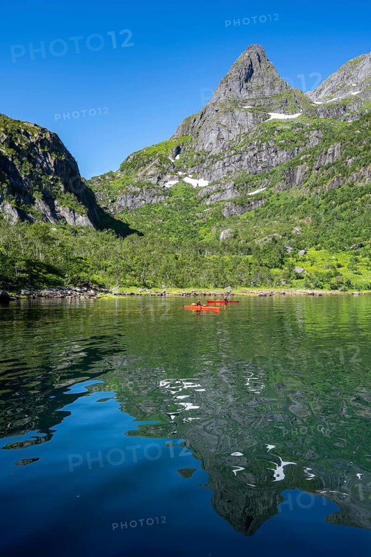 Two kayakers with red kayaks in the fjord Trollfjord, mountain peaks are reflected in the water, fjord landscape and mountains, Lofoten, Nordland, Norway