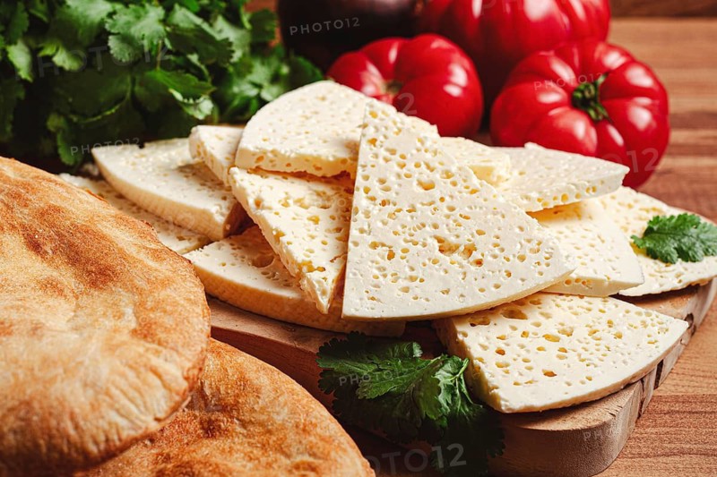 Georgian sliced cheese, on a wooden chopping board, with tomatoes with herbs and lavash, rustic style, Georgian cuisine, no people