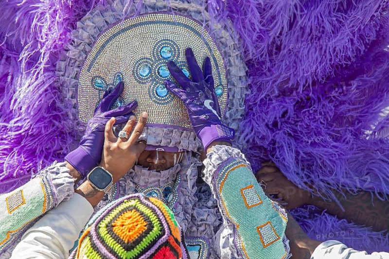 New Orleans, Louisiana - A man gets help with his headdress at the Mardi Gras Indians' Super Sunday parade. African-Americans create elaborate costumes for the annual event to honor Native Americans who, during slavery, helped helped people escape and gave them refuge