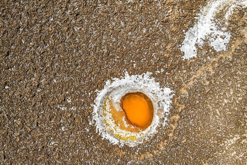 Top view, aerial capture of a vibrant orange and white salt formation embedded in the textured landscape of Salar de Antofalla, in Catamarca, Argentina