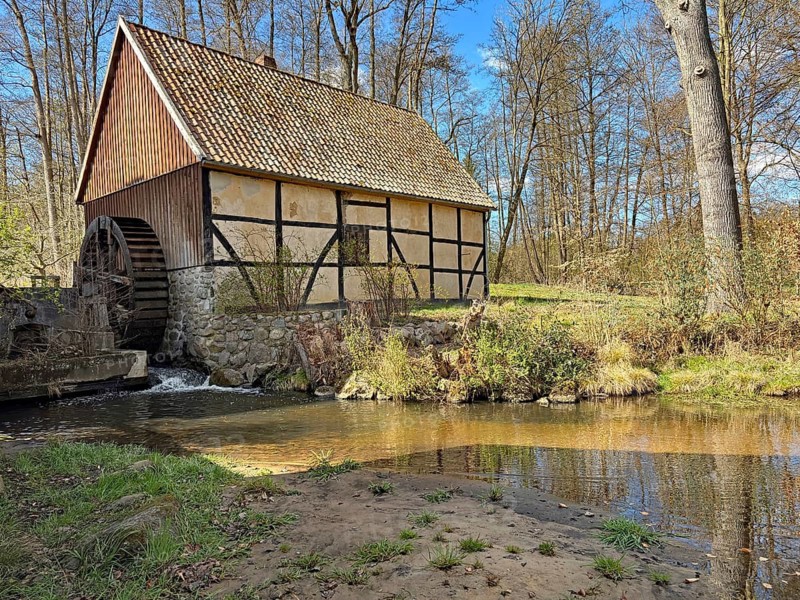 Historic mill on a stream in the middle of the forest under a blue sky, watermill, Jiggel, Wendland, Lower Saxony, Germany