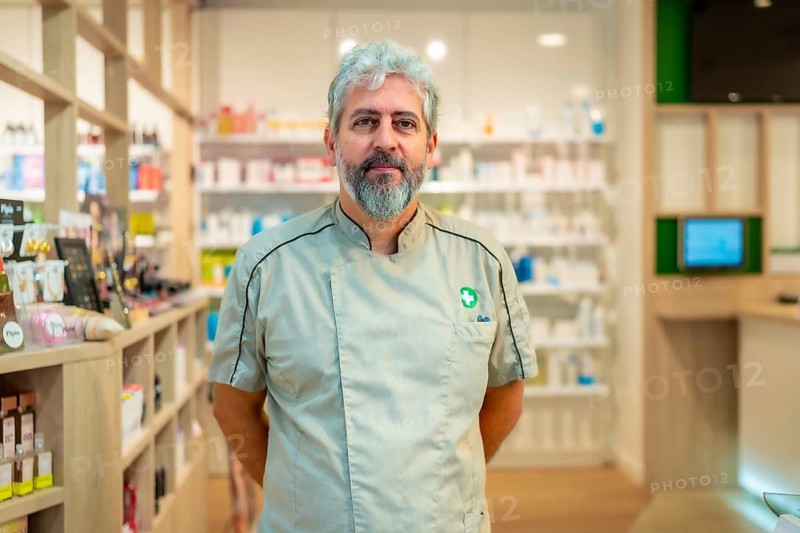 Portrait of the owner of a pharmacy standing arms on back in the store