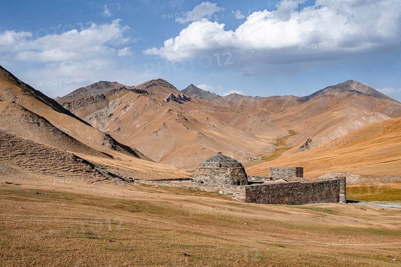 Historic caravanserai Tash Rabat from the 15th century, with yellow hills, Atbashy district in the Naryn region, Kyrgyzstan