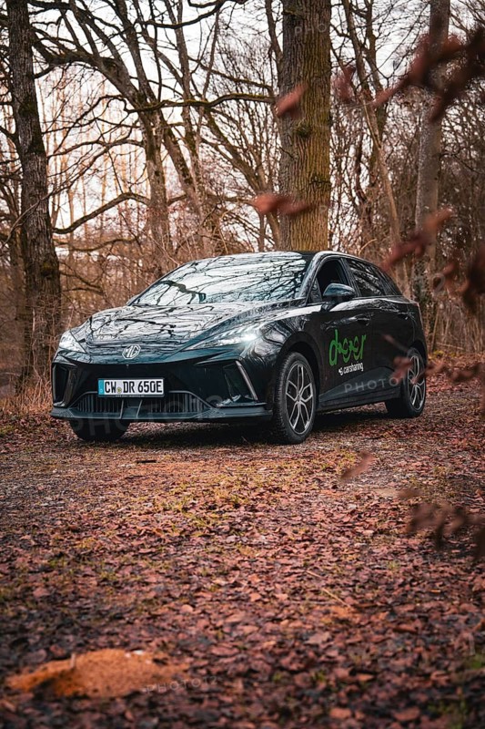 Black limousine with lettering on a forest path surrounded by trees, e-car sharing vehicle from Deer Mobility, Gechingen, Black Forest, Germany