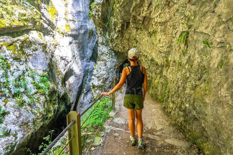 Female tourist exploring tolmin gorges on a sunny summer day, admiring the natural beauty of the slovenian canyon