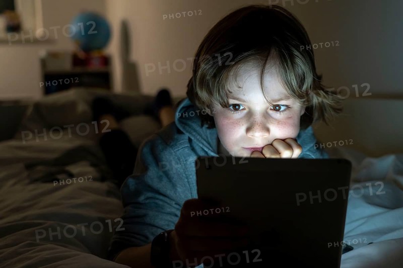 A boy plays computer games on a tablet PC