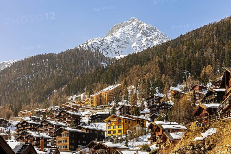 Snow-covered hotels and chalets built into the hillside, with the snow-capped summit of Sex de Marinda, Grimentz, Val d'Anniviers, Valais Alps, Canton of Valais, Switzerland