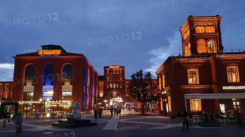 Lively evening square with illuminated brick buildings, Manufaktura, Lódz, Lodz, Poland