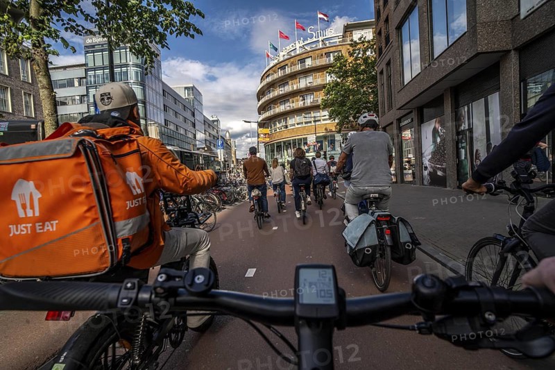 Ride your bike on the central cycle path on Lange Viestraat, Vredenburg, in the city centre of Utrecht, lanes for pedestrians, cyclists and public transport vehicles are separated, heavy cycle traffic, Netherlands