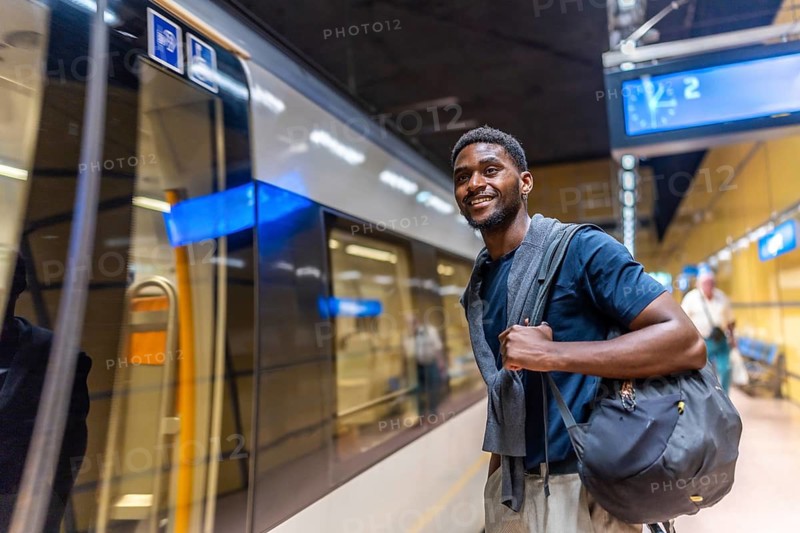 African entrepreneur waiting for the metro in the platform by night in the city