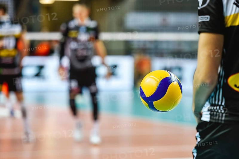 Volleyball ball flying near player before service with playing field in the background