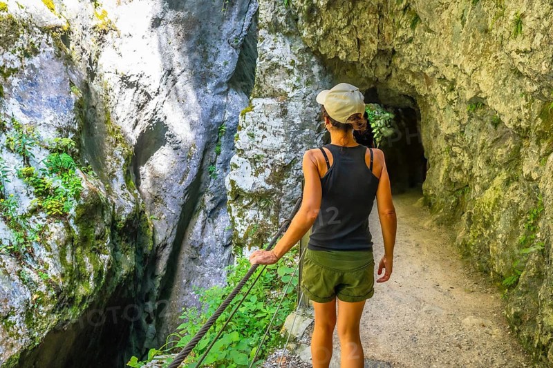 Woman enjoying a summer day while wandering through the stunning tolmin gorge in slovenia, surrounded by lush greenery and serene landscapes