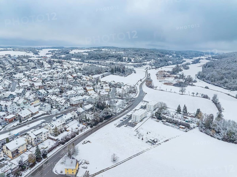 Aerial view of a snow-covered village with streets and houses under a grey sky, Aidlingen, Böblingen district, Germany