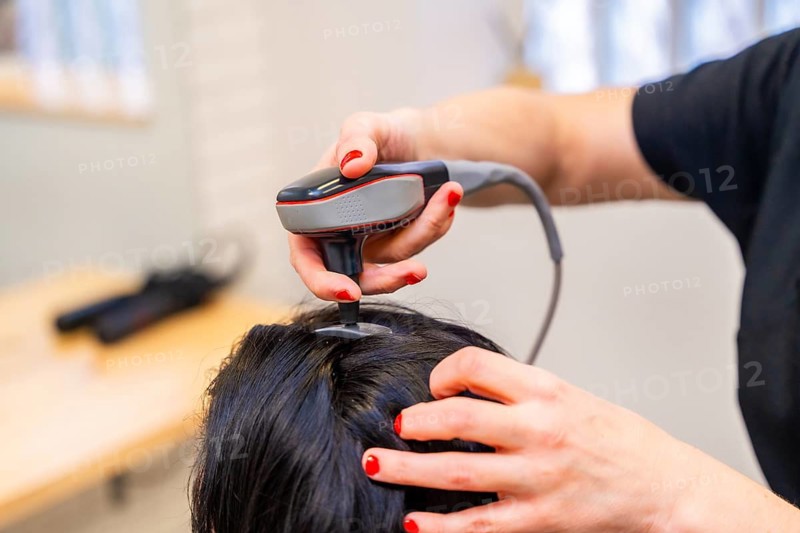 Close-up of a Woman receiving hair loss treatment at capillary clinic using radiowave therapy