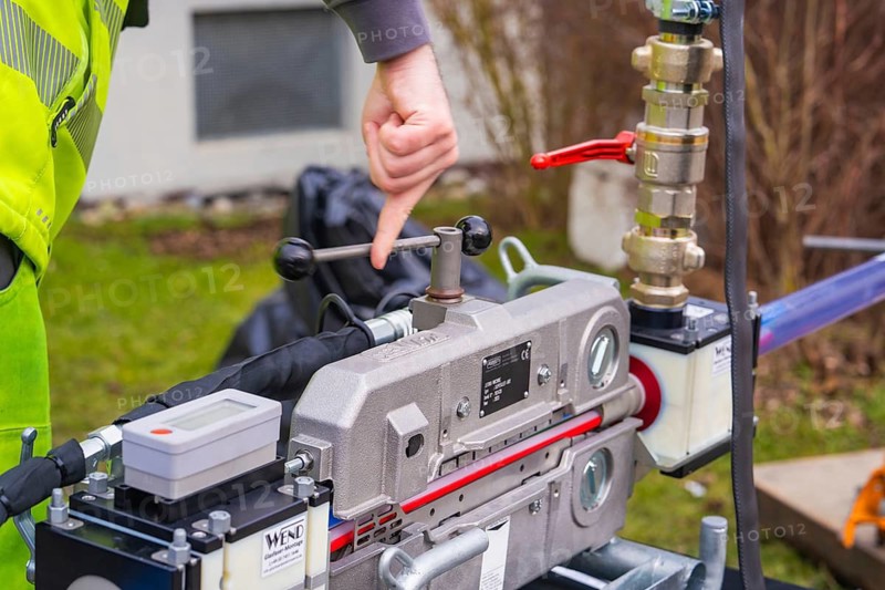 Person points to a mechanical device outdoors, Wend Glasfasermontage during the installation of fibre optic cable ducts, Meßkirch, district of Sigmaringen, Germany