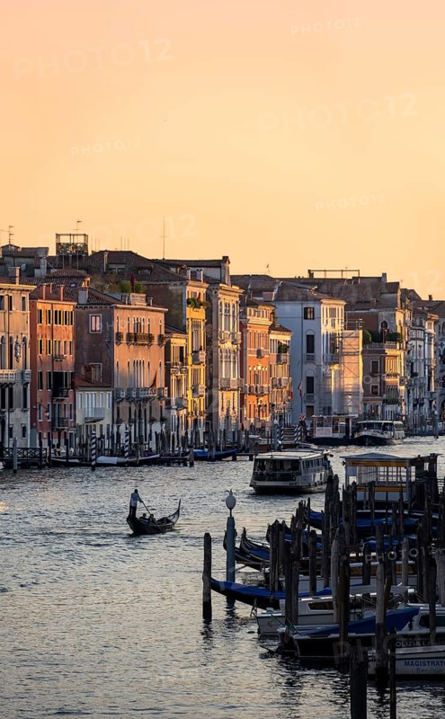 View of the Grand Canal with gondoliers at sunset, picturesque evening mood, view from the Rialto Bridge, Venice, Veneto, Italy