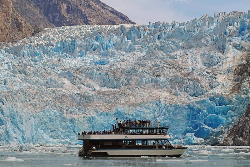 Small boat in front of a glacier calving into the sea, Tracy Arm Fiord, Tongass National Forest, Juneau, Inside Passage, Alaska, USA