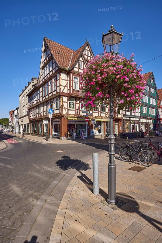 Lantern, flower decoration, garden petunia (Petunia × hybrida), ivy geranium (Pelargonium Peltatum), half-timbered houses, blue cloudless sky, intersection of Kanzleistraße with Hehlentorstraße and Schuhstraße, Celle, Lüneburger Heide, district of Celle, Lower Saxony, Germany