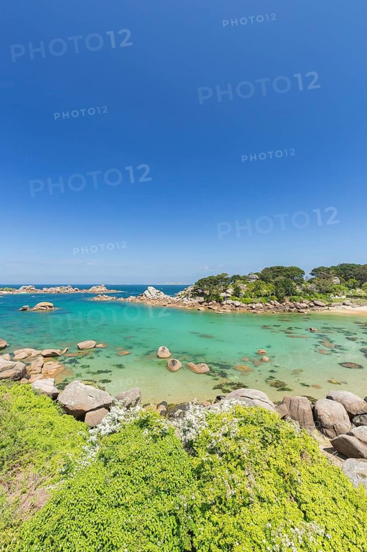 Beach with rocks and sand at the Plage Saint Guirec, with clear blue sky and colors as in the carribians